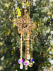 Winter’s Gold suncatcher with golden flower detailing and hanging iridescent crystals in sunlight