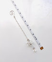 A silver-toned  beaded chain with a clear crystal angel drop pendant, shown next to a white measuring tape to indicate its length on a light gray background.