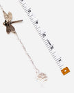 A silver-toned dragonfly suncatcher with a clear faceted crystal ball charm, displayed next to a measuring tape to show scale on a white background.