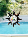 Sun shaped crystal prism SUNCATCHER with wavy rays and Swarovski hex star inside showing stunning colors from window.