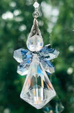 Close-up of the Saphoreus wizard angel crystal suncatcher showcasing the detailed sapphire blue crystal wings and iridescent clear glass body hanging against a sparkly green background.