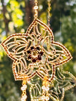 Close-up of the Winter's Gold handcrafted suncatcher highlighting the warm brown rhinestones nestled inside the intricate golden filigree flower design.