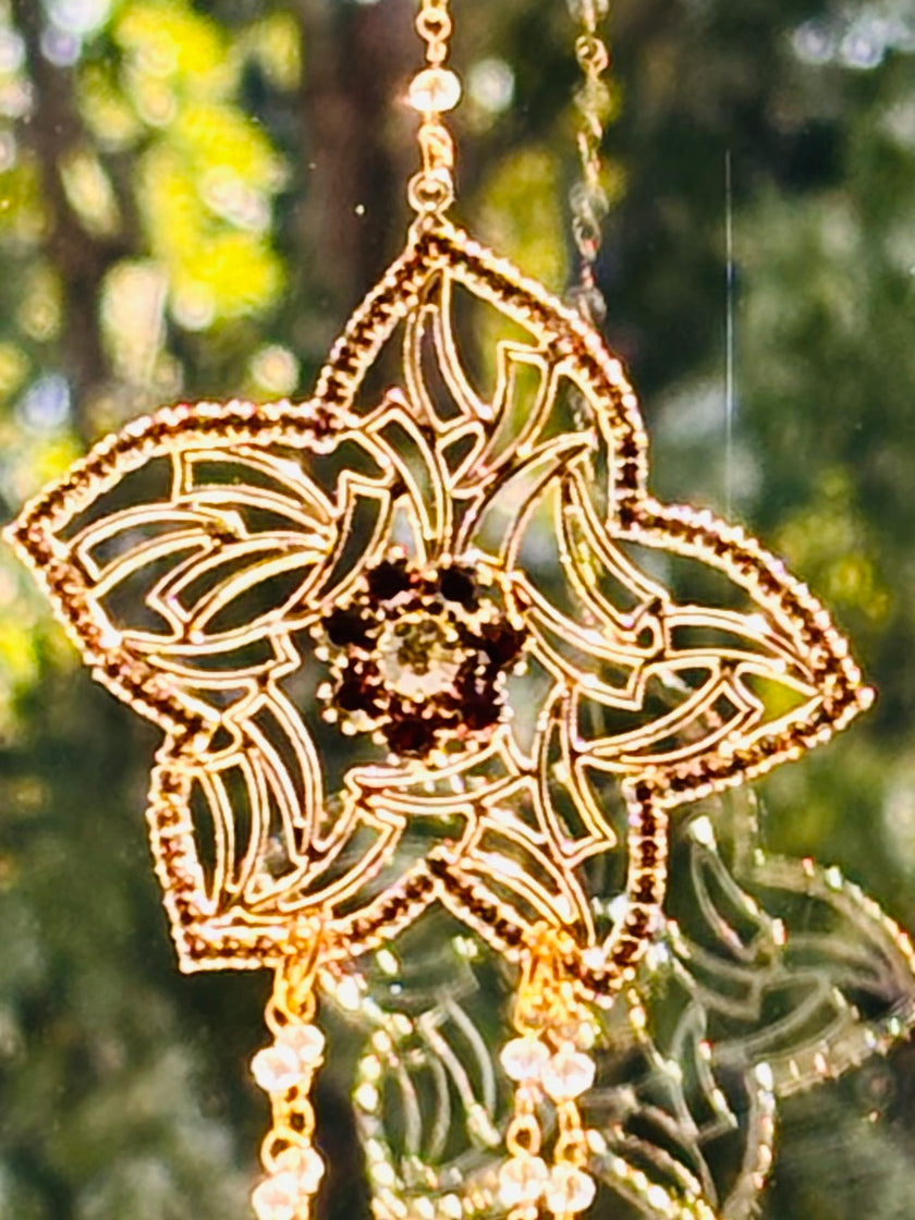 Close-up of the Winter's Gold handcrafted suncatcher highlighting the warm brown rhinestones nestled inside the intricate golden filigree flower design.