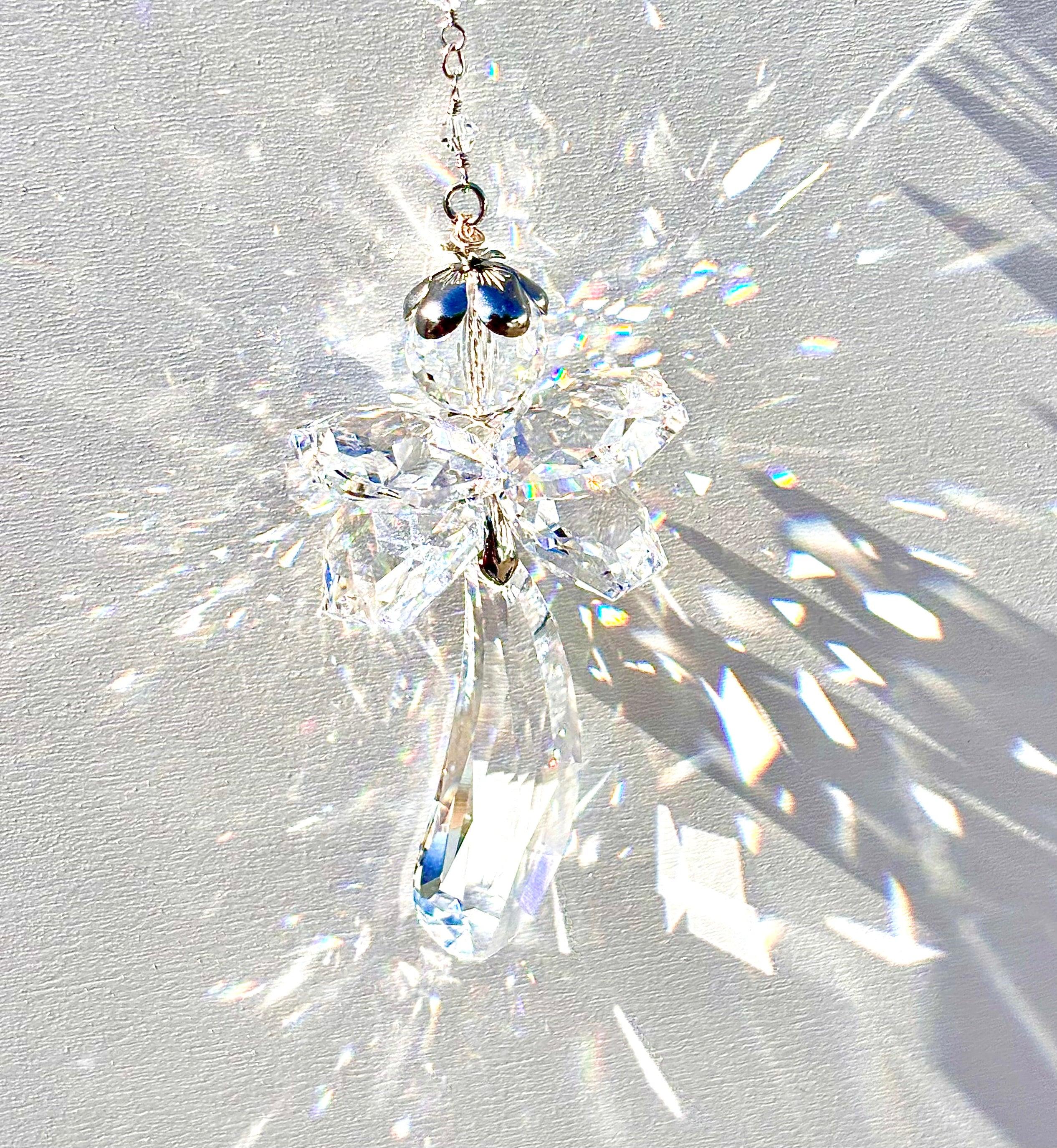 Unique handmade Fairy Angel suncatcher made from Swarovski crystals being illuminated by the sun and casting incredible prisms. 