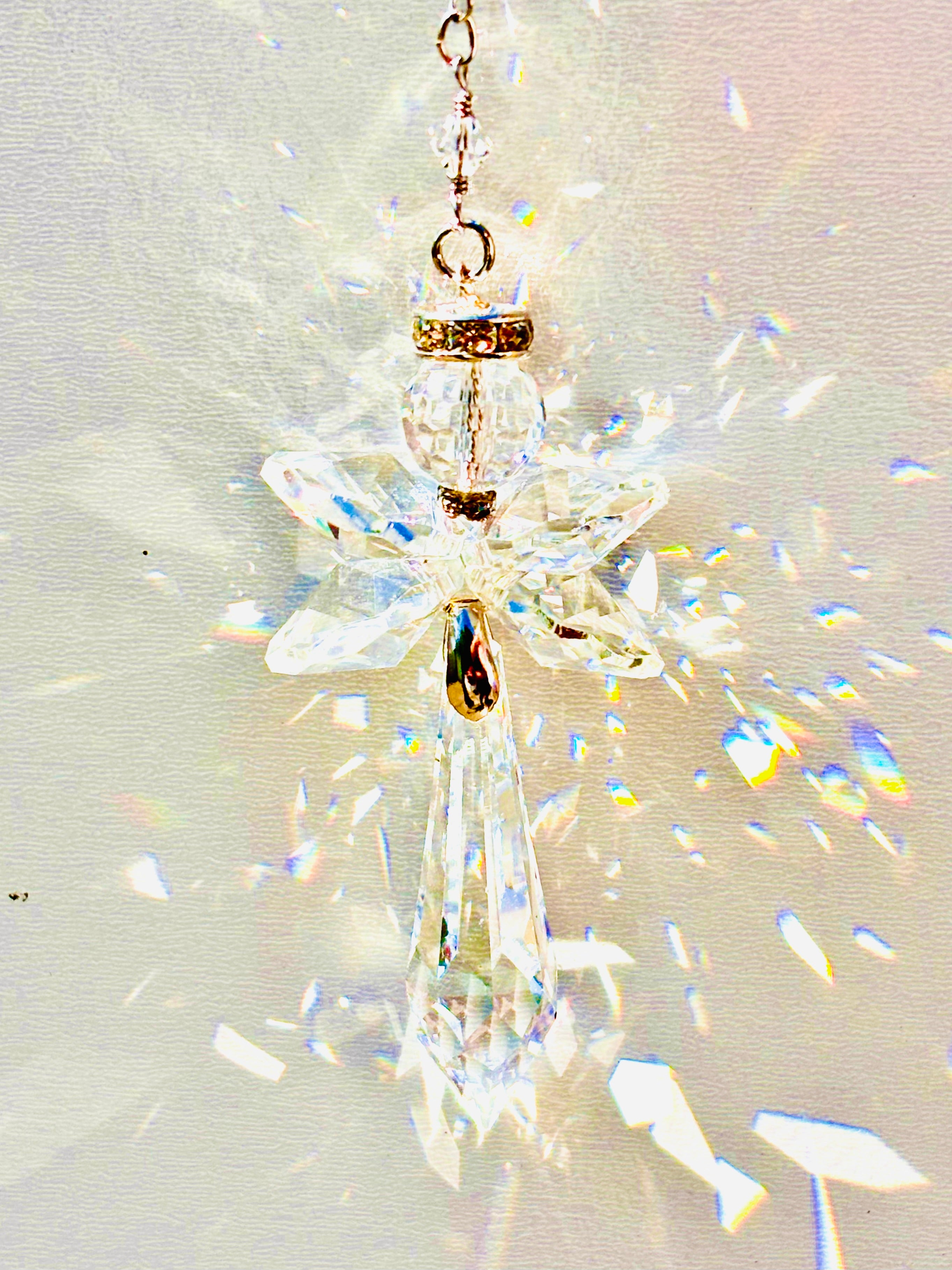 Handmade angel suncatcher made with Swarovski crystals emitting prisms of colors as the sun hits it. 