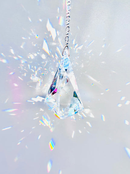 Rare Swarovski Vibe crystal hanging on a crystal strand emitting a magnitude of light and rainbows. 