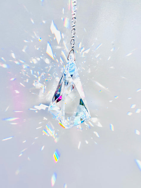 Rare Swarovski Vibe crystal hanging on a crystal strand emitting a magnitude of light and rainbows. 