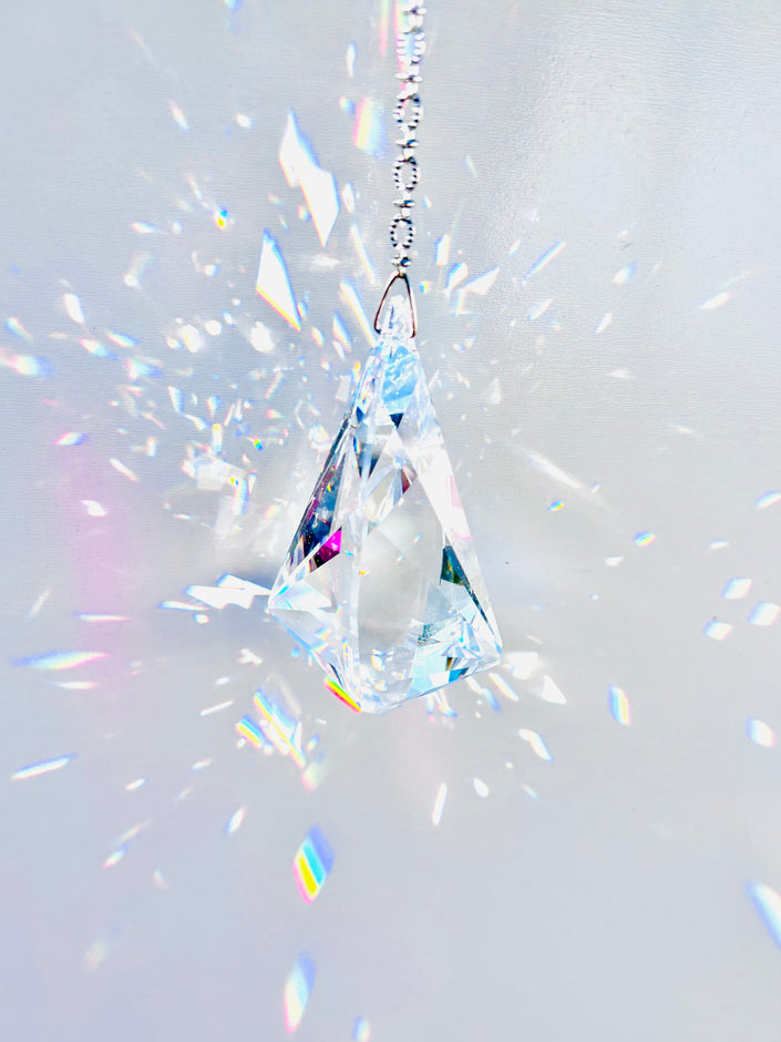 Rare Swarovski Vibe crystal hanging on a crystal strand emitting a magnitude of light and rainbows. 