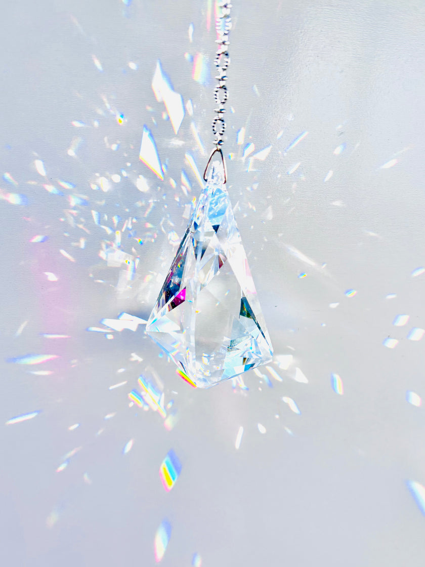 Rare Swarovski Vibe crystal hanging on a crystal strand emitting a magnitude of light and rainbows. 