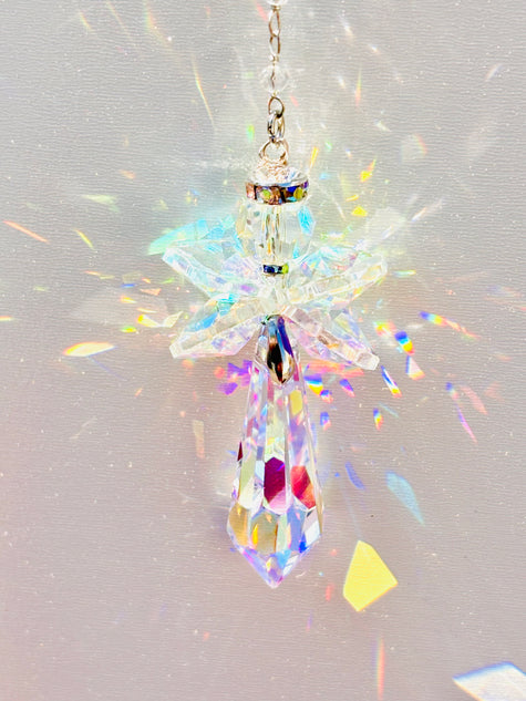 Handmade angel suncatcher glowing as the sun hits it creating a rainbow of colors.