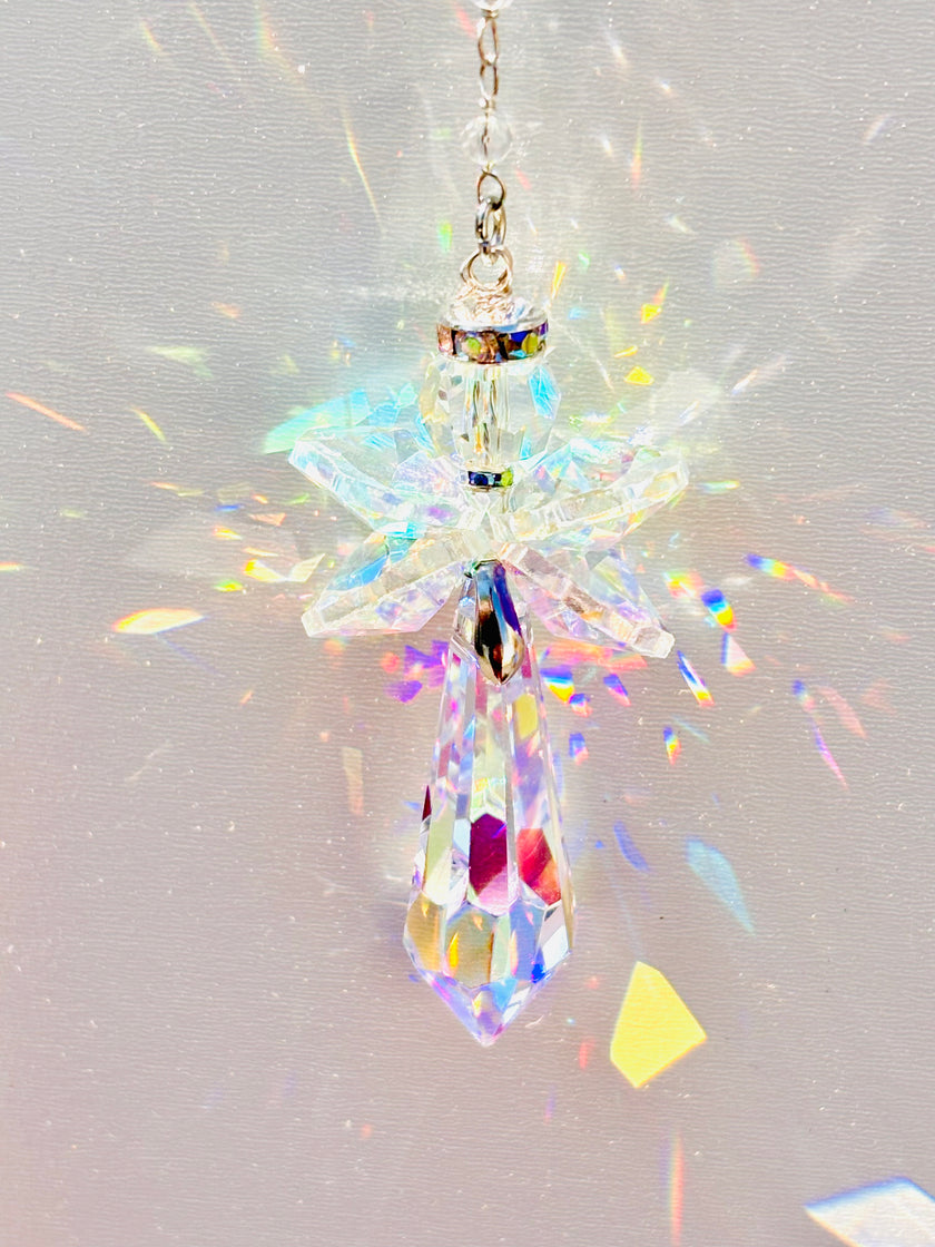 Handmade angel suncatcher glowing as the sun hits it creating a rainbow of colors.