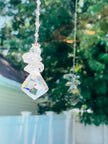 A large crystal angel spinning and illuminating in a bright window as it spins. 
