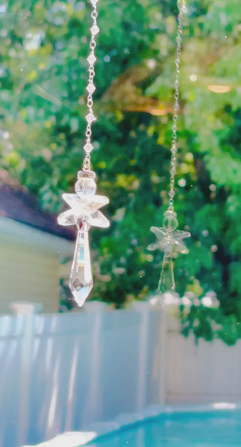 A crystal angel shooting sparks and reflection in a bright window as it spins. 