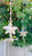 A handmade Swarovski aurora borealis crystal butterfly spins in the window flickering prisms and its own reflection in the sun.
