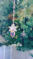 A pink crystal fairy spinning in a bright window shooting sparks of light and reflection.