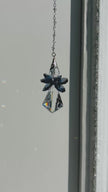 Handcrafted Saphoreus wizard angel crystal suncatcher twisting gently indoors, highlighting the deep sapphire blue glass wings and faceted clear glass body.